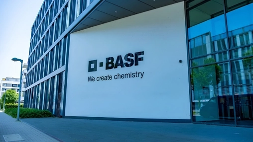 A BASF office building exterior with the company logo and We create chemistry slogan on a white wall